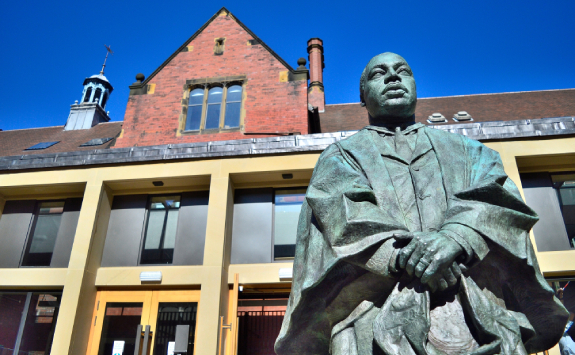A two-metre tall bronze sculpture of Dr Martin Luther King Jr. He is sculpted wearing a graduation gown